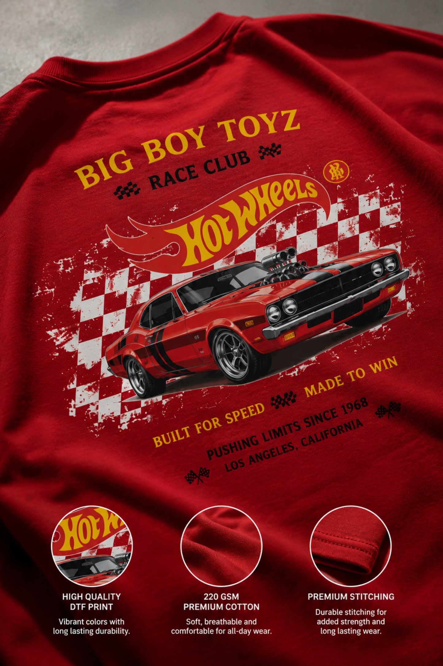 Red BIG BOY TOYZ x Hot Wheels oversized t-shirt featuring a vintage red Hot Wheels car graphic, checkered flag pattern, and brand logos. Showcase print quality and fabric.