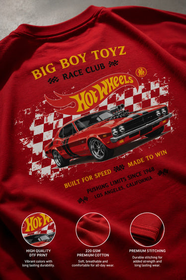 Red BIG BOY TOYZ x Hot Wheels oversized t-shirt featuring a vintage red Hot Wheels car graphic, checkered flag pattern, and brand logos. Showcase print quality and fabric.