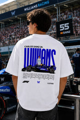 Model wearing white POPCASE Carlos Sainz Williams Racing oversized t shirt with blue W logo at Formula 1 circuit pitlane