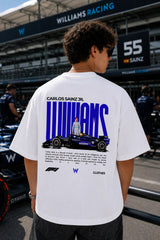 Model wearing white POPCASE Carlos Sainz Williams Racing oversized t shirt with blue W logo at Formula 1 circuit pitlane
