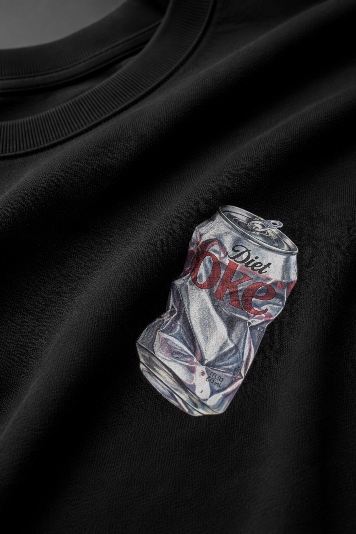 Black oversized t-shirt with hyper-realistic crushed Diet Coke can chest graphic