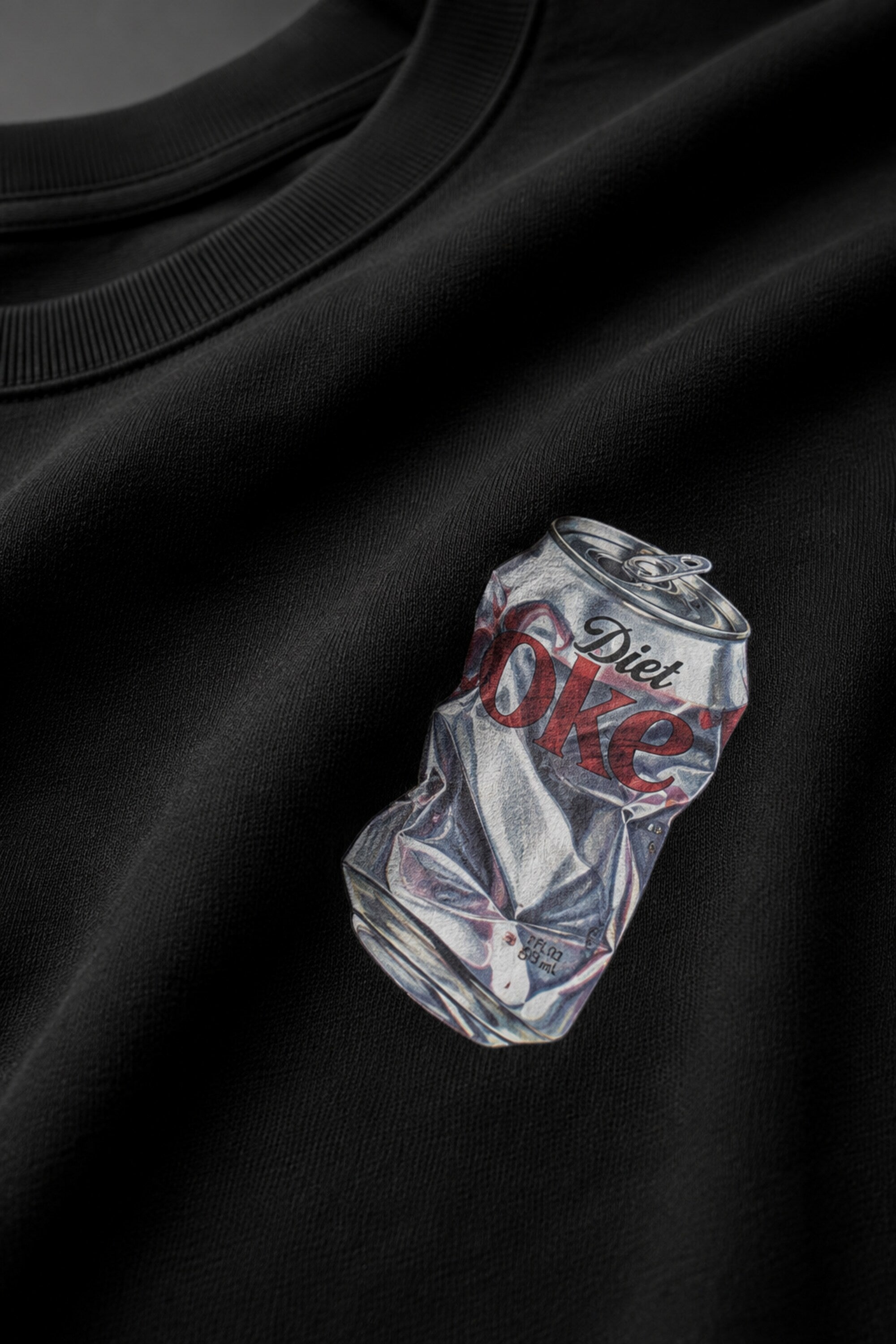 Black oversized t-shirt with hyper-realistic crushed Diet Coke can chest graphic