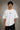 Man wearing a white CR7 oversized t-shirt with black CR7 logo. Studio shot with grey background.