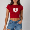 Model wearing a red CROPTOP Cherry crop top with a cute cherry and bow graphic, paired with denim shorts. The top has a flattering cropped fit. - red