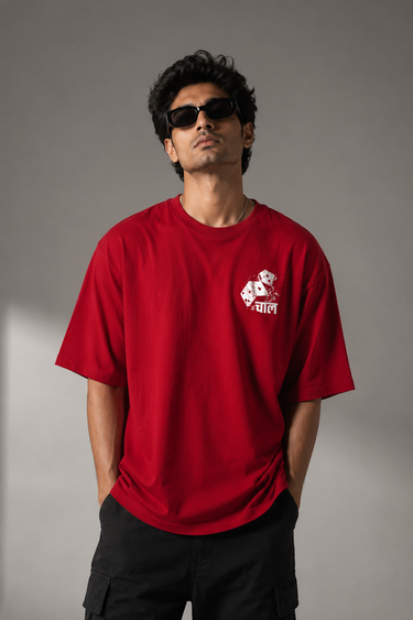 CHAL brand red oversized t-shirt with white graphic print of dice and text. Model wearing the t-shirt to showcase the relaxed, oversized fit. - red