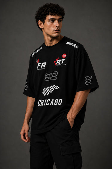 Black oversized t-shirt with 'Chicago' graphic print and racing-inspired logos. Offers premium streetwear style.