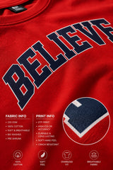 Male model wearing a red oversized t-shirt with 'Believe' printed in navy blue and white collegiate-style lettering.