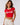Back view of a woman wearing a red Coco-Cola crop top with white trim and beige high-waisted pants against a white background.