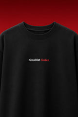 On a Diet Coke black oversized t-shirt with white and red chest print