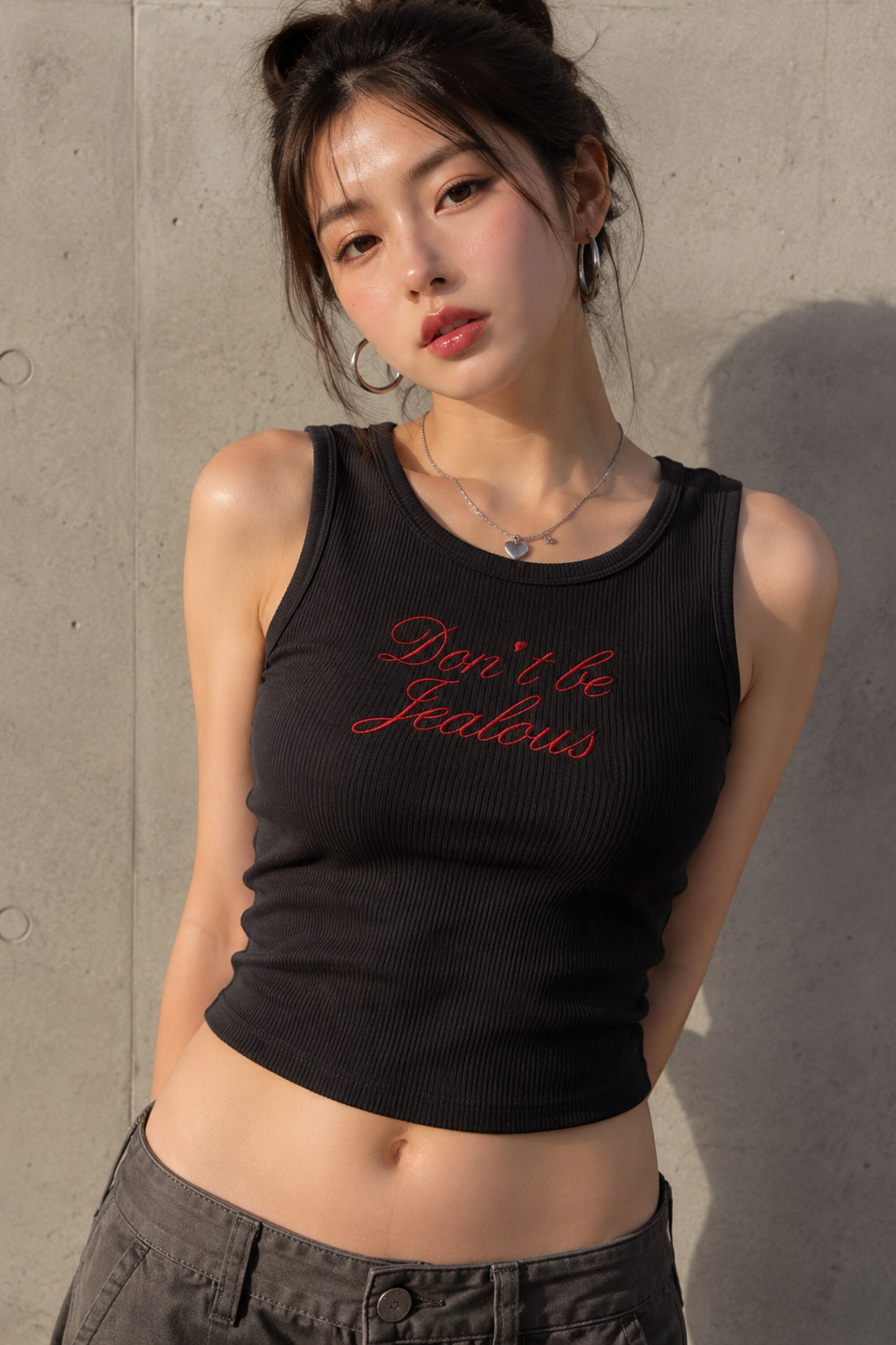 Black ribbed crop tank top with red cursive Don't Be Jealous embroidery on model - black