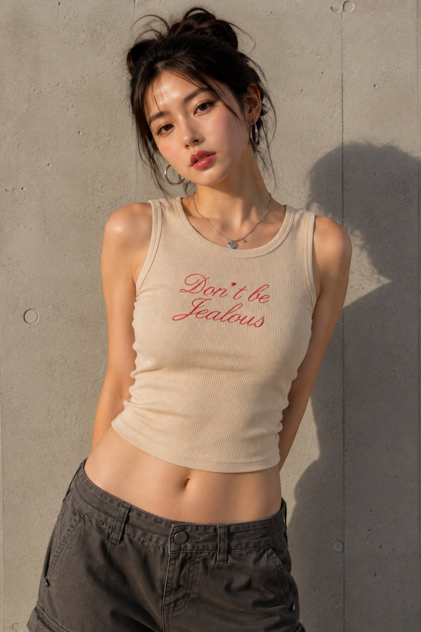 Black ribbed crop tank top with red cursive Don't Be Jealous embroidery on model - beige
