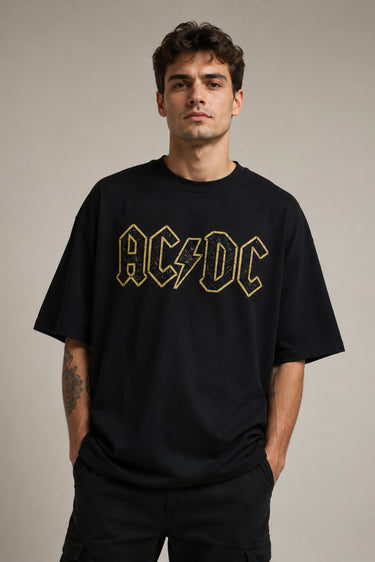 Man wearing a black AC/DC t-shirt against a plain background