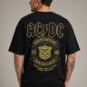 Person wearing a black t-shirt with AC/DC graphic design on the back against a gray background