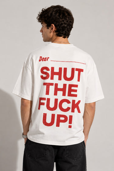Person wearing a white t-shirt with red text on the back, standing against a plain background