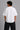 Model wearing a white DIMENSION oversized t-shirt with a black and blue graphic print and a silver chain necklace.