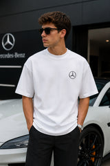 Model wearing white POPCASE George Russell Mercedes oversized t shirt with star logo on chest and teal MERCEDES race car back graphic