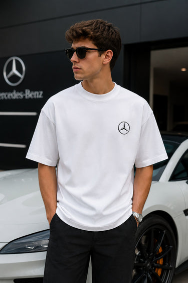 Model wearing white POPCASE George Russell Mercedes oversized t shirt with star logo on chest and teal MERCEDES race car back graphic