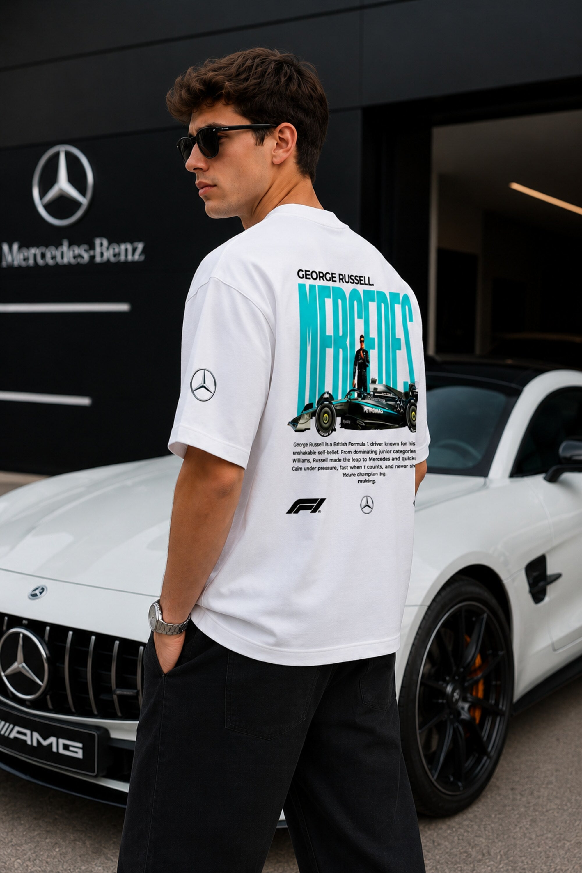 Model wearing white POPCASE George Russell Mercedes oversized t shirt with star logo on chest and teal MERCEDES race car back graphic