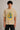 Black oversized t-shirt with the Hogwarts crest and 'Hogwarts' text in yellow, worn by a person. Features detailed coat of arms with lions, snakes, badgers, and eagles. - beige