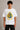 Black oversized t-shirt with the Hogwarts crest and 'Hogwarts' text in yellow, worn by a person. Features detailed coat of arms with lions, snakes, badgers, and eagles. - white