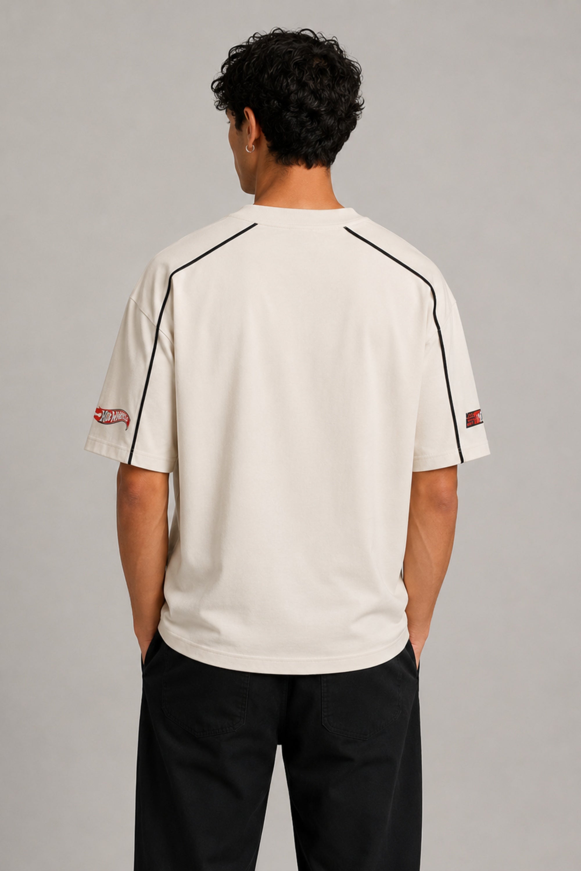 Beige oversized t-shirt with large red and black HOT WHEELS 'Original Since 1968' graphic print on the front, showcasing premium fabric texture.