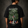 Man wearing a black Kalpvruksh oversized t-shirt with a colorful tree and bird graphic print on the back. Features Hindi script and 'The Wishing Tree' text. Streetwear style.