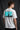 Model wearing white POPCASE Kimi Antonelli Mercedes oversized t shirt with teal MERCEDES Petronas F1 car back graphic and bio text