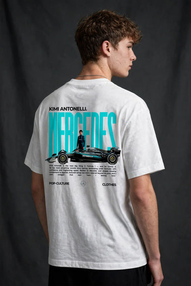 Model wearing white POPCASE Kimi Antonelli Mercedes oversized t shirt with teal MERCEDES Petronas F1 car back graphic and bio text