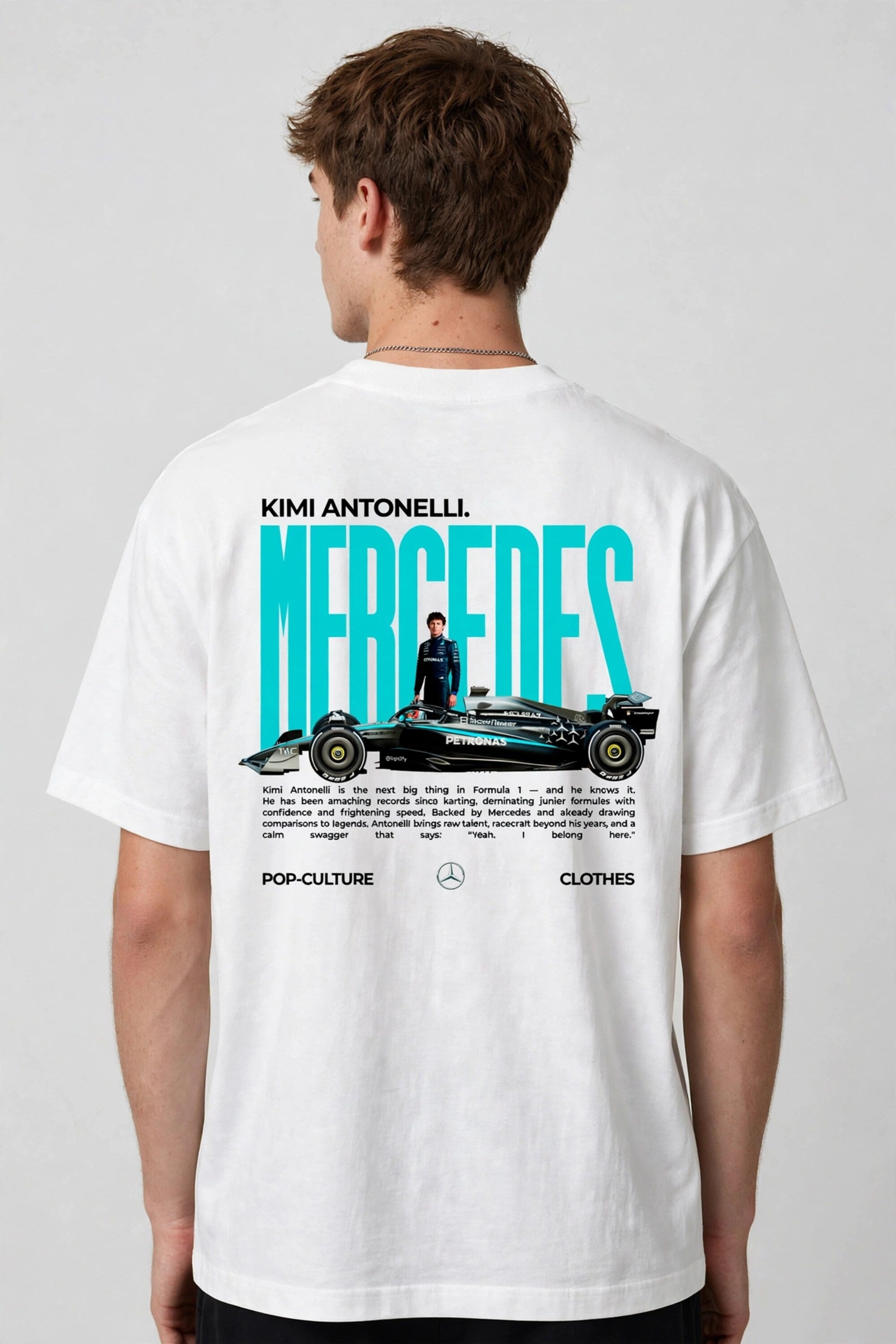 Model wearing white POPCASE Kimi Antonelli Mercedes oversized t shirt with teal MERCEDES Petronas F1 car back graphic and bio text