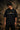 Man wearing a black KARNA oversized t-shirt with a sun graphic and Sanskrit text. Streetwear style, premium cotton feel.