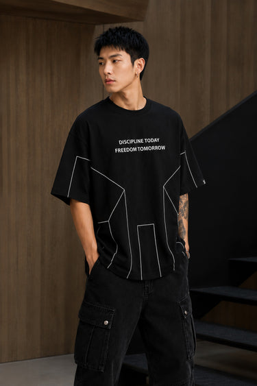 BLESS black oversized t-shirt with white graphic text 'DISCIPLINE TODAY FREEDOM TOMORROW' and abstract geometric lines.