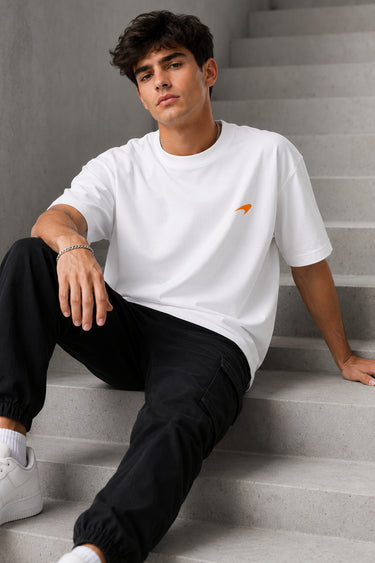Model wearing white POPCASE Lando Norris McLaren oversized t shirt with orange speed mark logo on left chest