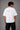 Back view of a man wearing a white LA 32 Drive oversized t-shirt with black text graphic. Model wears black cargo pants.