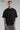 Black POPCASE LAUNCH oversized t-shirt featuring a large, distressed gray wing graphic print. Close-up on the premium fabric and detailed print for a streetwear aesthetic.