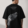 Black POPCASE LAUNCH oversized t-shirt featuring a large, distressed gray wing graphic print. Close-up on the premium fabric and detailed print for a streetwear aesthetic. - black