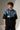 LAYERS black oversized t-shirt with a dynamic blue, white, and orange abstract graphic print, featuring "THE ONLY C" text detail, showcasing its premium fabric and streetwear aesthetic.