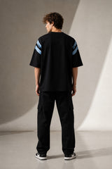 LAYERS black oversized t-shirt with a dynamic blue, white, and orange abstract graphic print, featuring "THE ONLY C" text detail, showcasing its premium fabric and streetwear aesthetic.