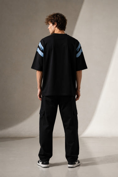 LAYERS black oversized t-shirt with a dynamic blue, white, and orange abstract graphic print, featuring "THE ONLY C" text detail, showcasing its premium fabric and streetwear aesthetic.