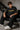 Model wearing an anthracite black Mbappe oversized t-shirt with gold "MBAPPE" graphic and signature, Real Madrid and number 7 logos on sleeves.