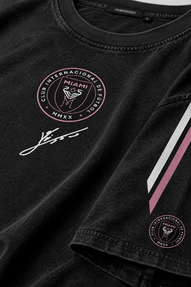 Man wearing an anthracite black Messi oversized t-shirt with a circular team logo and signature, showcasing the relaxed fit and premium fabric.