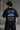 Black oversized t-shirt featuring a detailed white blueprint and a silver Nissan Skyline R34 with blue racing stripes graphic. Includes text 'The Nissan Skyline GTR'.