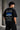 Black oversized t-shirt featuring a detailed white blueprint and a silver Nissan Skyline R34 with blue racing stripes graphic. Includes text 'The Nissan Skyline GTR'.