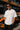 Model wearing white POPCASE Oscar Piastri McLaren oversized t shirt with orange McLaren speed mark logo and McLaren race car back graphic