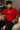 Model wearing a red oversized t-shirt with 'Just a 90's Kid' graphic. The tee has a relaxed fit, paired with black jeans and white sneakers, embodying a retro streetwear style.