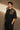 Back view of a person wearing a black ART ON OVERSIZED TSHIRT with gold embroidered detail on the left sleeve. Shows the oversized fit and premium streetwear aesthetic.