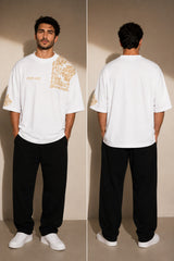 Back view of a person wearing a black ART ON OVERSIZED TSHIRT with gold embroidered detail on the left sleeve. Shows the oversized fit and premium streetwear aesthetic. - white