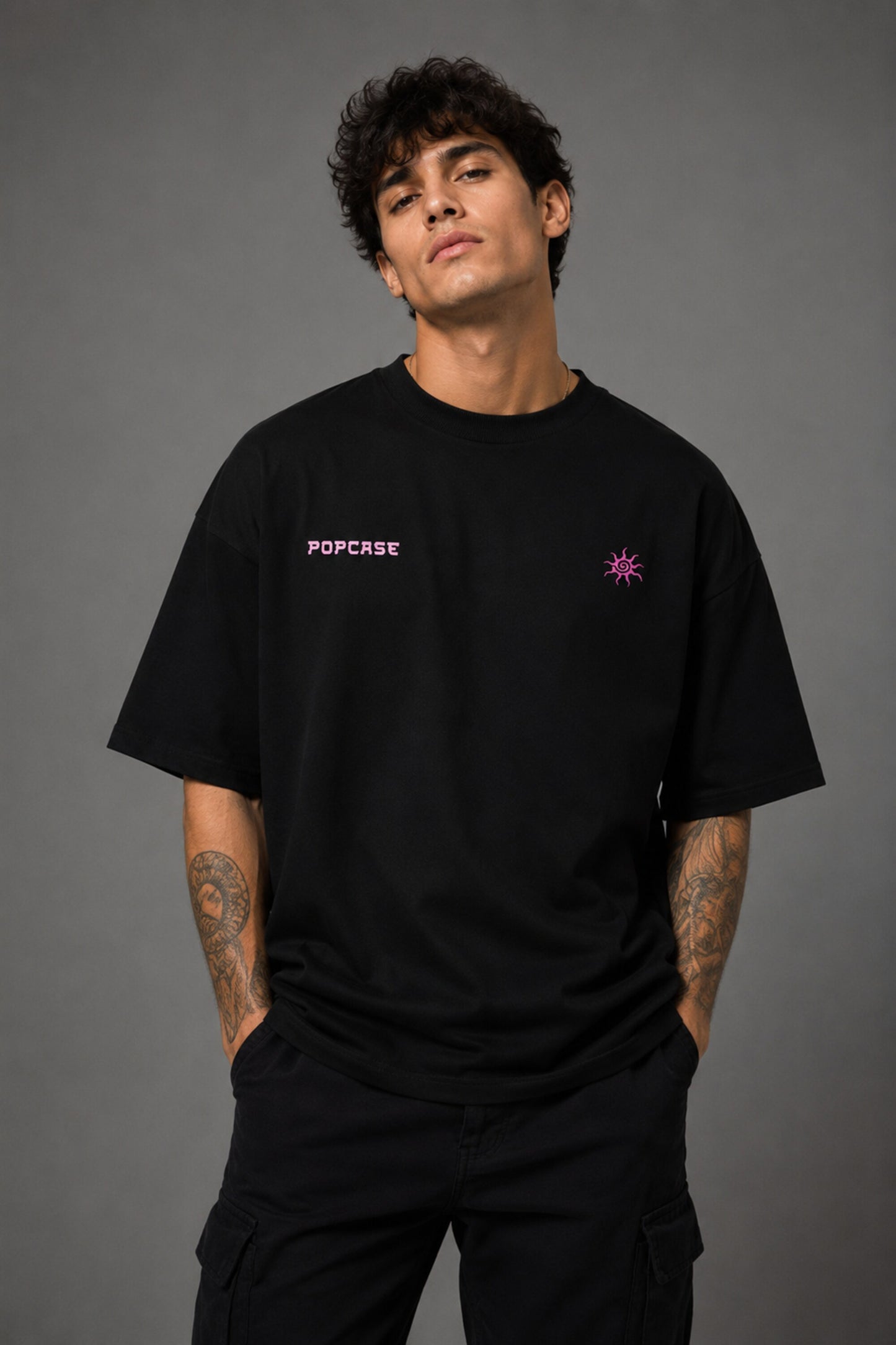 Black POPCASE oversized tshirt with Bad Intentions Only pink gothic text and tribal sun print on back, worn with black cargo pants