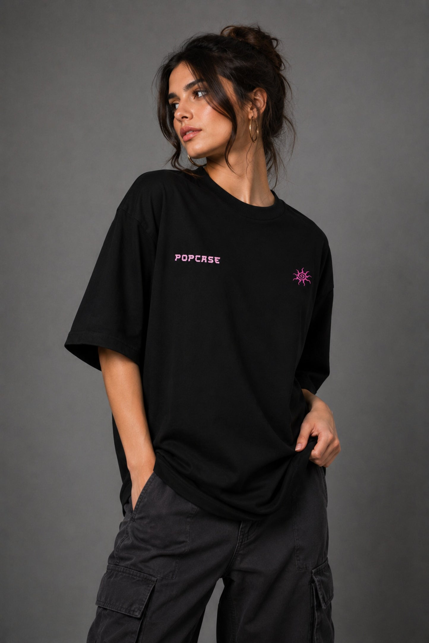 Black POPCASE oversized tshirt with Bad Intentions Only pink gothic text and tribal sun print on back, worn with black cargo pants