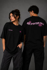 Black POPCASE oversized tshirt with Bad Intentions Only pink gothic text and tribal sun print on back, worn with black cargo pants