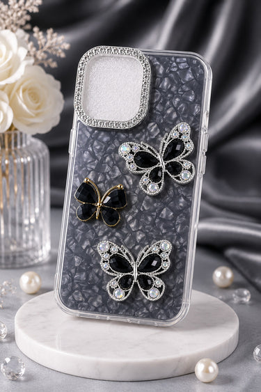 Phone case with butterfly designs on a marble stand with flowers and pearls in the background